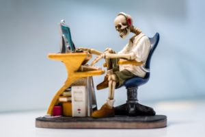 Skelett vor einem Computer